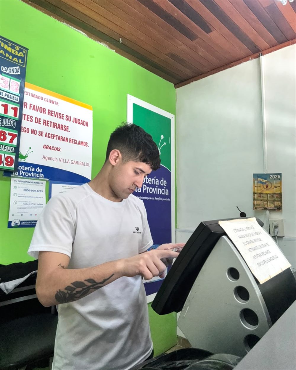 Kevin cargando una jugada en la terminal de la agencia de lotería Villa Garibaldi.